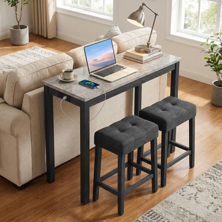 3-piece bar table set featuring a faux marble top, gray upholstered stools, and a side charging station for convenience.