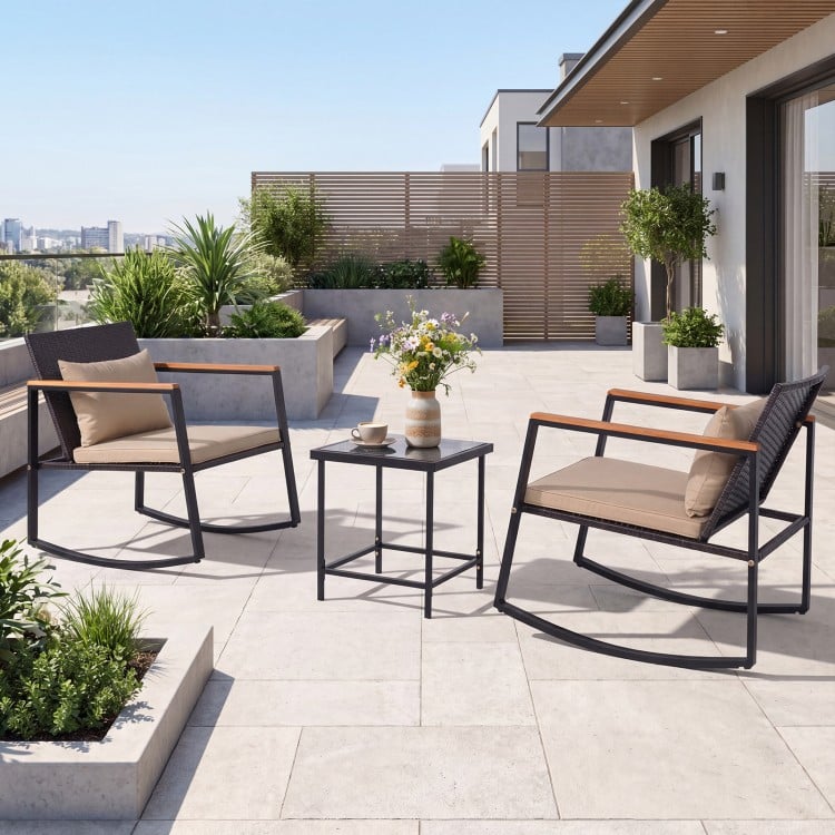 Outdoor rocking bistro set featuring two wicker chairs with soft cushions and a tempered glass coffee table for patio.