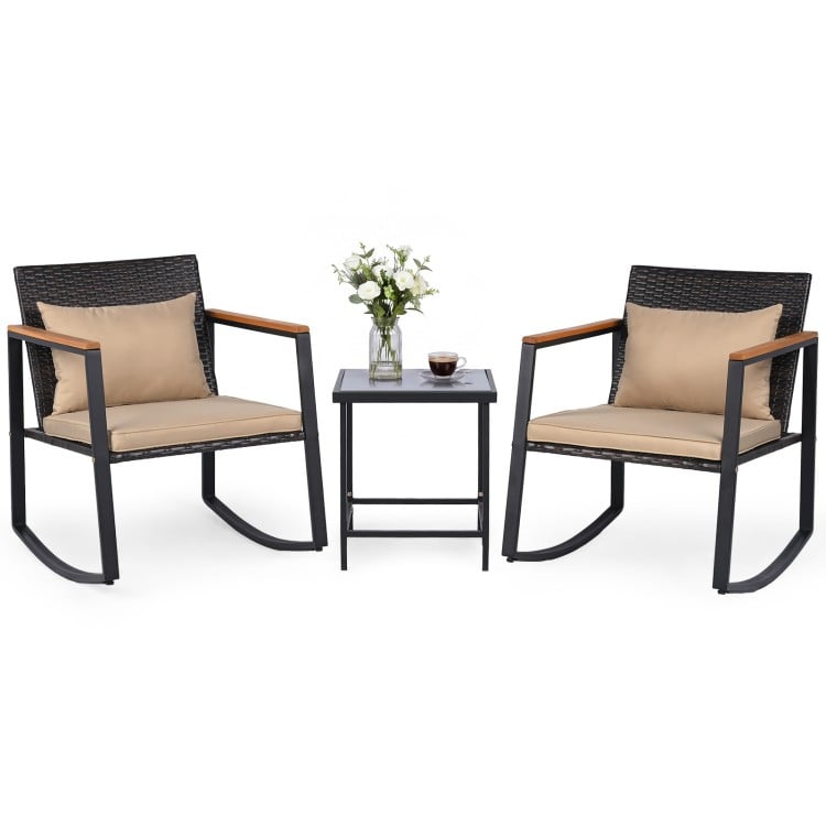 3-piece outdoor rocking bistro set with wicker chairs, soft cushions, and tempered glass table for patio relaxation.