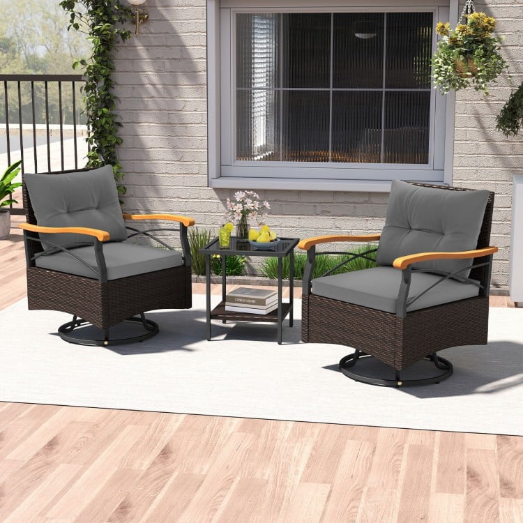 Two gray swivel chairs with acacia wood armrests and a tempered glass side table, perfect for outdoor relaxation.
