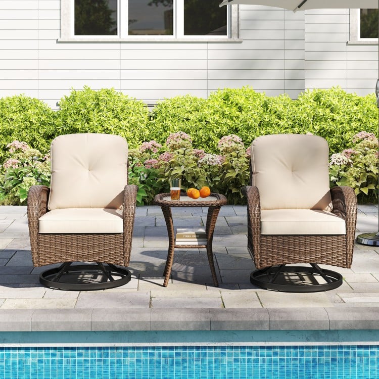 Two brown patio swivel rockers with thick cushions beside a stylish tempered glass side table by the poolside.