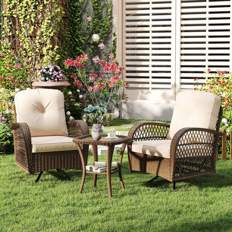 Patio swivel rocker set featuring brown woven rattan chairs with thick cushions and a tempered glass side table.
