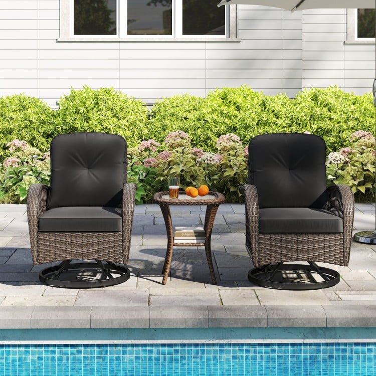 Two black cushioned swivel rockers with a glass side table, perfect for relaxing by the poolside or backyard.