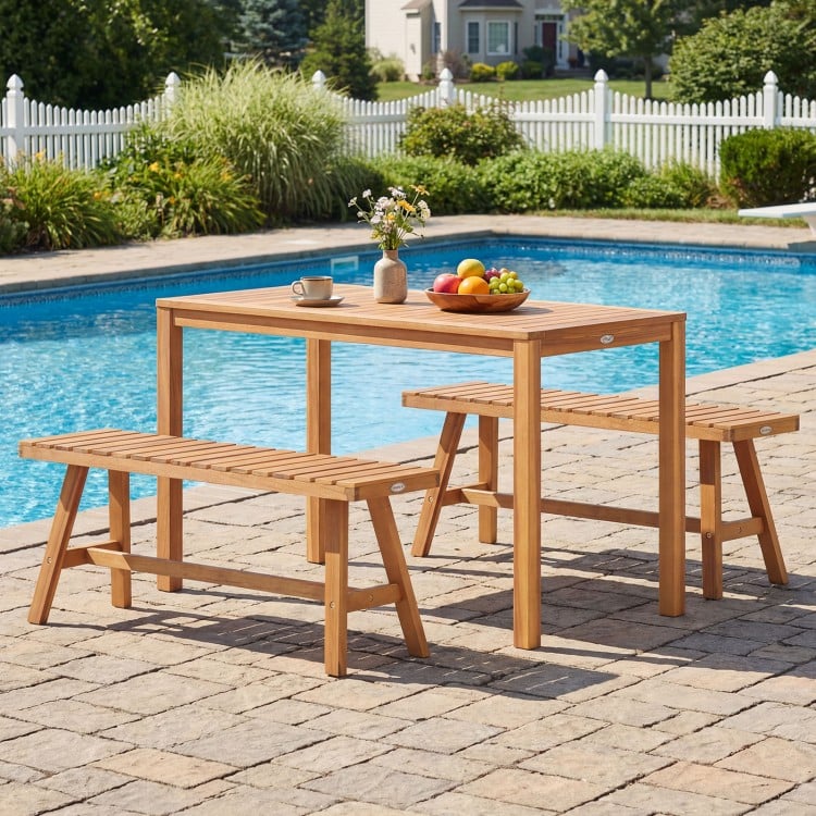 Acacia wood patio dining set with rectangular table and slatted benches, perfect for outdoor gatherings by the pool.