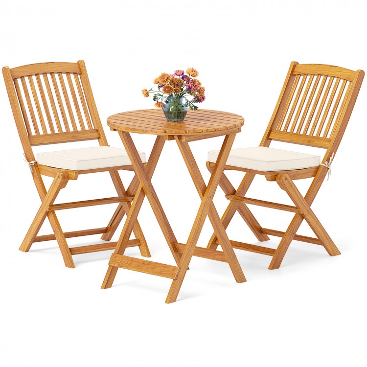 Acacia wood patio bistro set with beige cushions, featuring two folding chairs and a round table for outdoor dining.