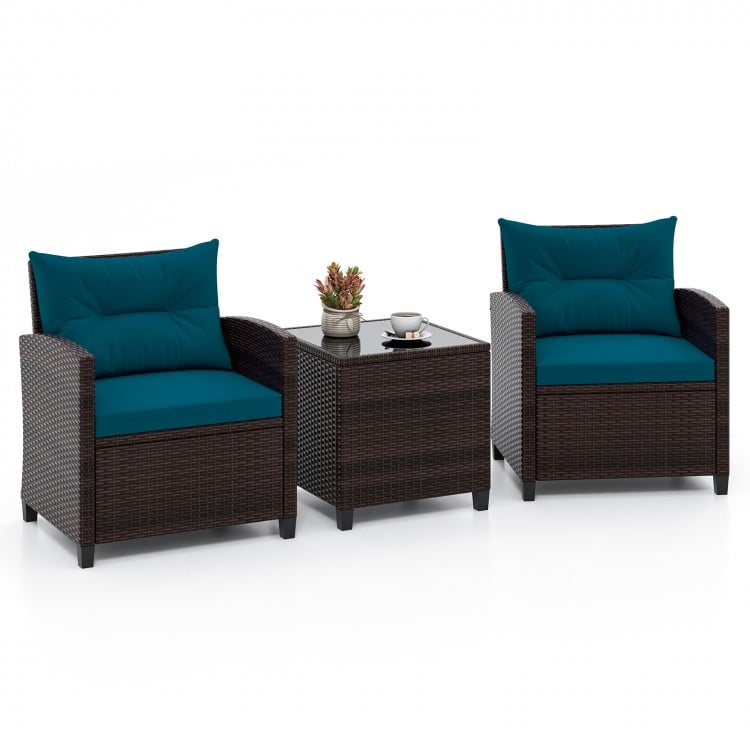Two rattan patio chairs with peacock blue cushions and a coffee table, perfect for outdoor relaxation.