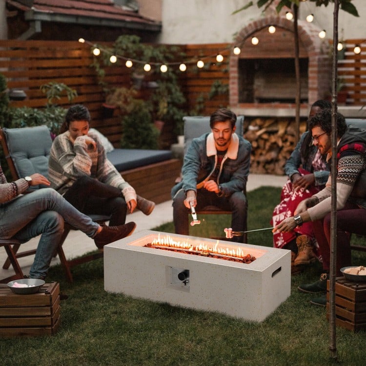 Rectangle terrazzo fire pit table with 50,000 BTU heat output, surrounded by friends for outdoor gatherings.