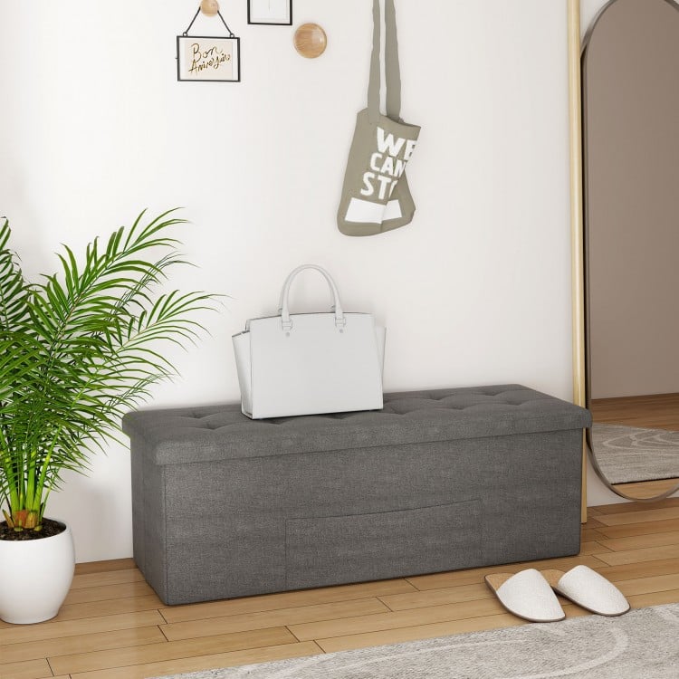 Dark gray folding storage ottoman bench with padded seat, ideal for entryway or bedroom organization.