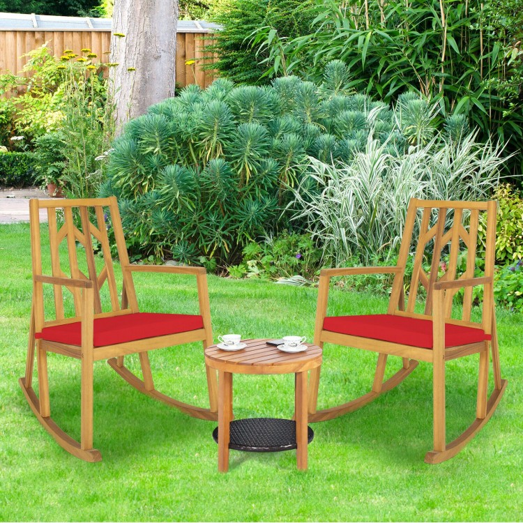 Two acacia wood rocking chairs with red cushions and a small table, perfect for garden relaxation.