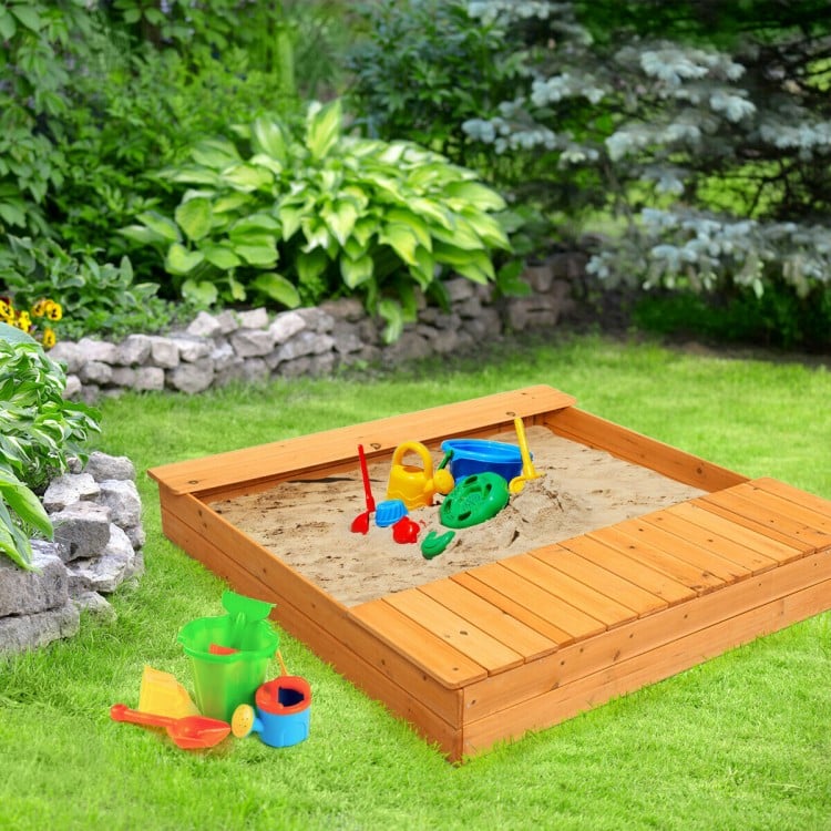 Cedar sandbox with plastic toys and storage boxes, perfect for kids to dig and play in the backyard.