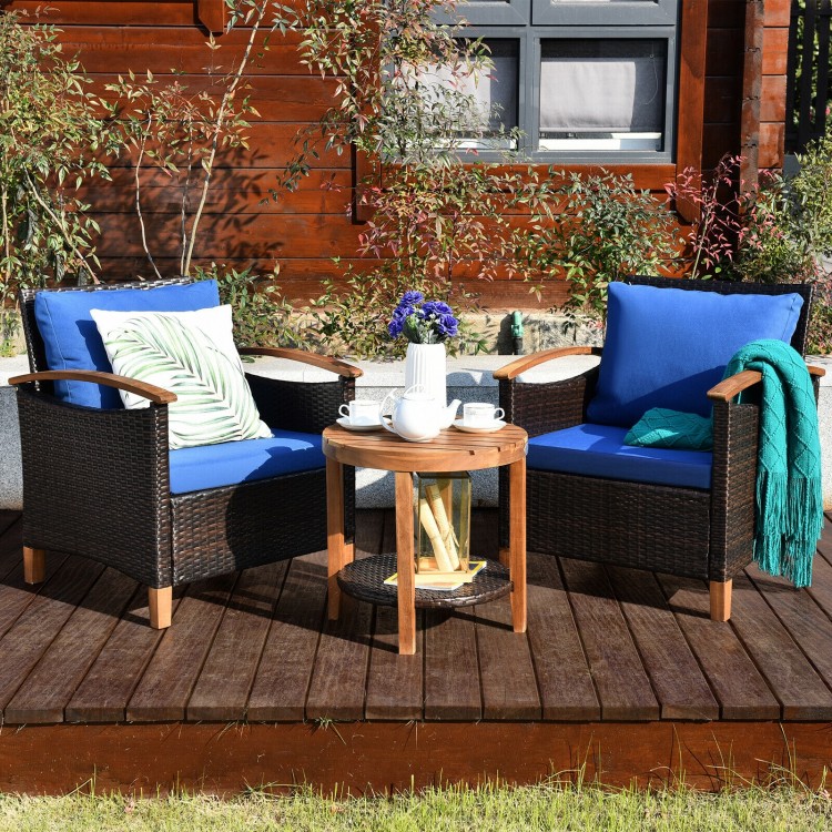 Two blue cushioned patio chairs with a solid wood frame and a coffee table, perfect for outdoor relaxation.