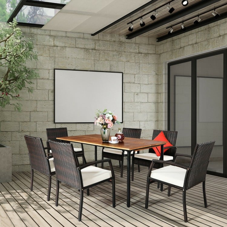 7-piece patio rattan dining set with acacia wood table and cushioned armchairs, perfect for outdoor gatherings.