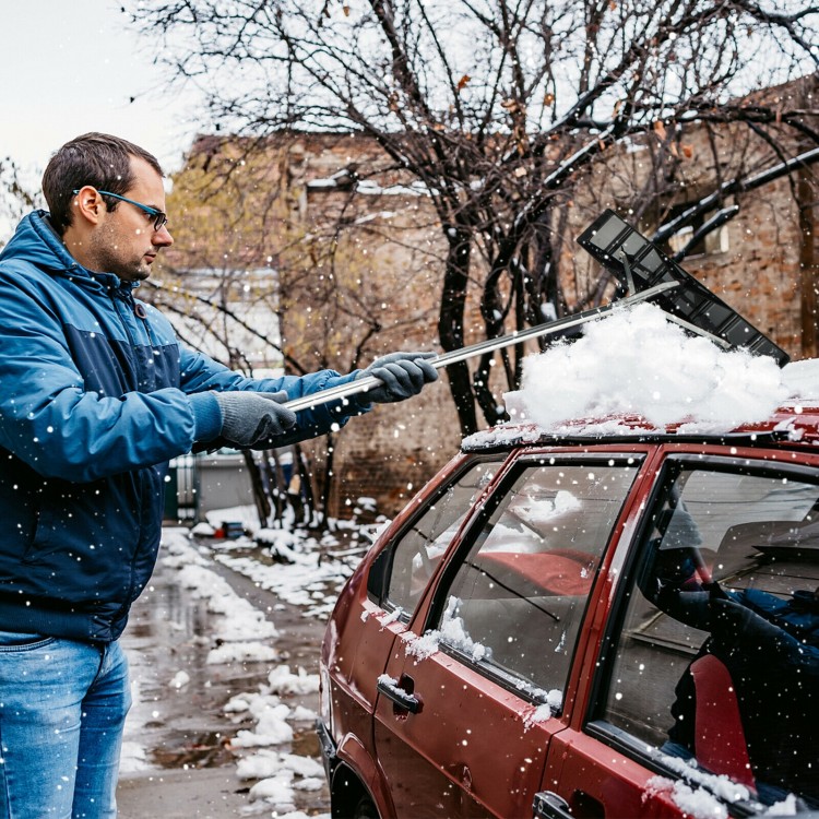 Extendable 20 ft aluminum snow roof rake with anti-slip handle, efficiently removing snow from a car roof.