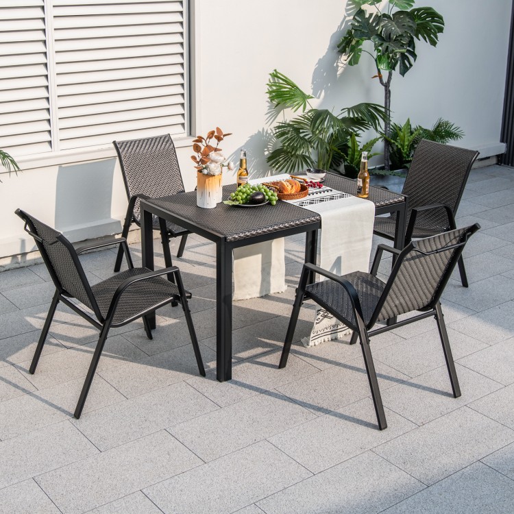 Four stackable brown patio rattan dining chairs with wicker woven seats, set around a table for outdoor dining.