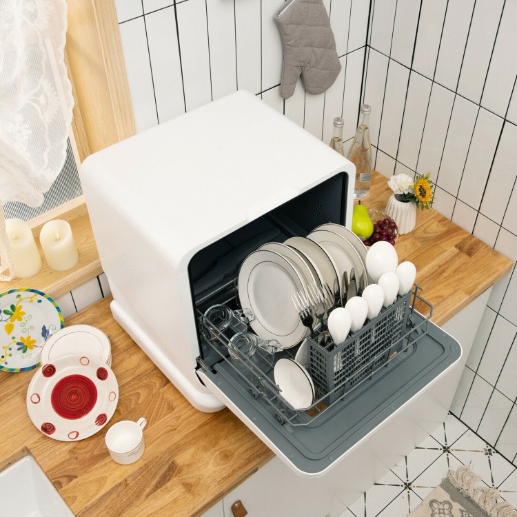 Countertop dishwasher with openable water tank, loaded with plates and cutlery, ideal for small spaces like condos or.