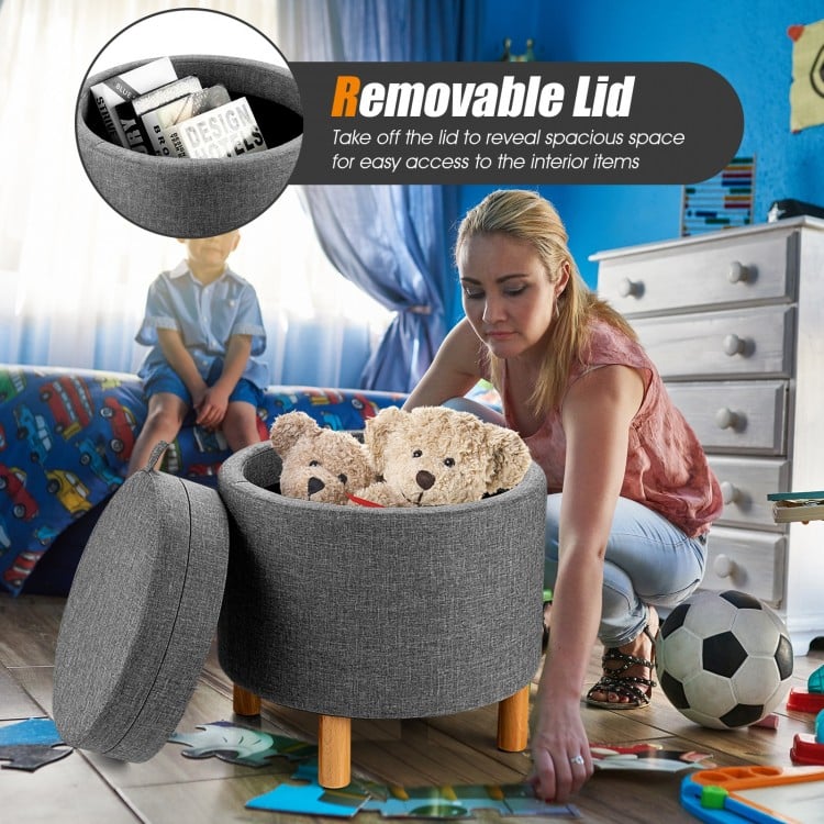 Round gray fabric storage ottoman with removable lid and wooden tray, perfect for toys and extra seating in any room.