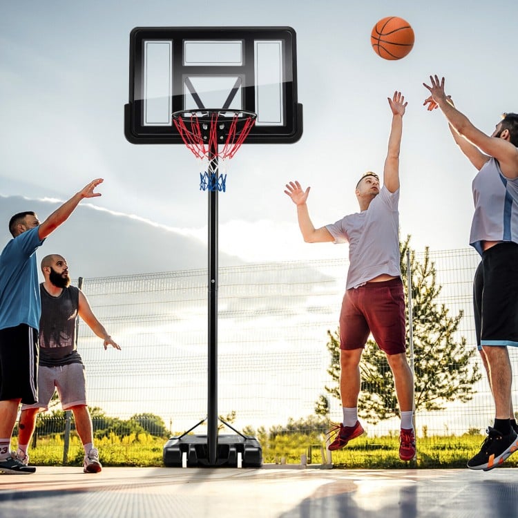 Basketball hoop system with adjustable height, shatterproof backboard, and two players shooting a basketball outdoors.