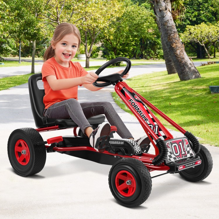Child enjoying the red pedal-powered go-kart on a pathway, featuring four wheels and a comfortable adjustable seat.