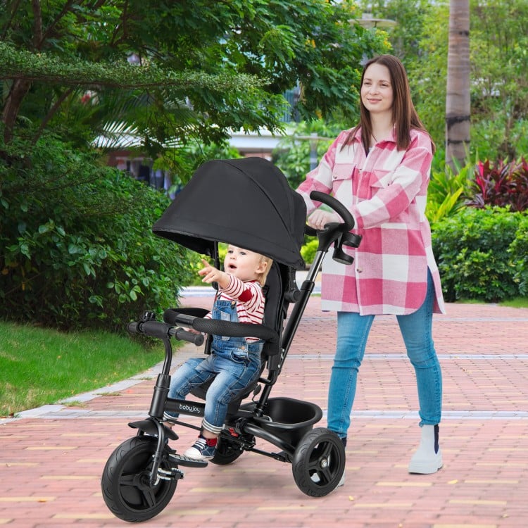 4-in-1 baby tricycle in black with adjustable canopy, reversible seat, and 5-point safety harness for versatile use.