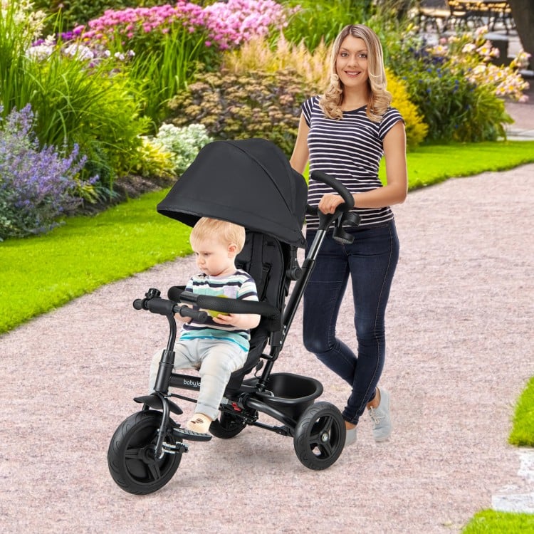 4-in-1 black baby tricycle with reversible seat, adjustable canopy, and 5-point safety harness for outdoor strolls.