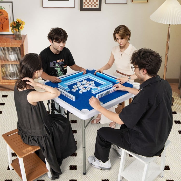 Four players enjoying a game at the 35-inch navy folding mahjong table with cup holders, featuring a smooth felt.