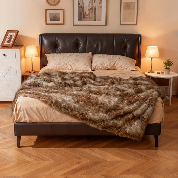 Luxurious 540GSM faux raccoon fur blanket on a bed, featuring a soft texture and double-sided design for comfort.