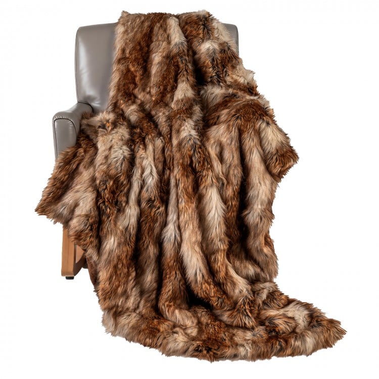 Luxurious 540GSM faux raccoon fur blanket draped over a chair, featuring a soft texture for cozy warmth and style.