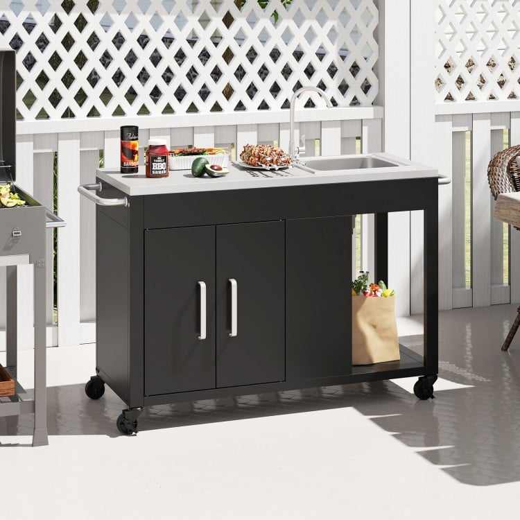 Outdoor grill table with sink and stainless steel top, featuring lockable wheels and storage for patio or backyard use.