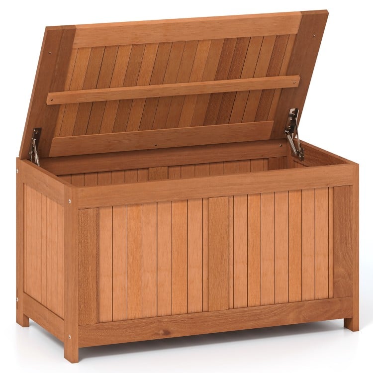 Wooden 52-gallon patio deck box with flip top, ideal for cushions and outdoor storage, suitable for various settings.