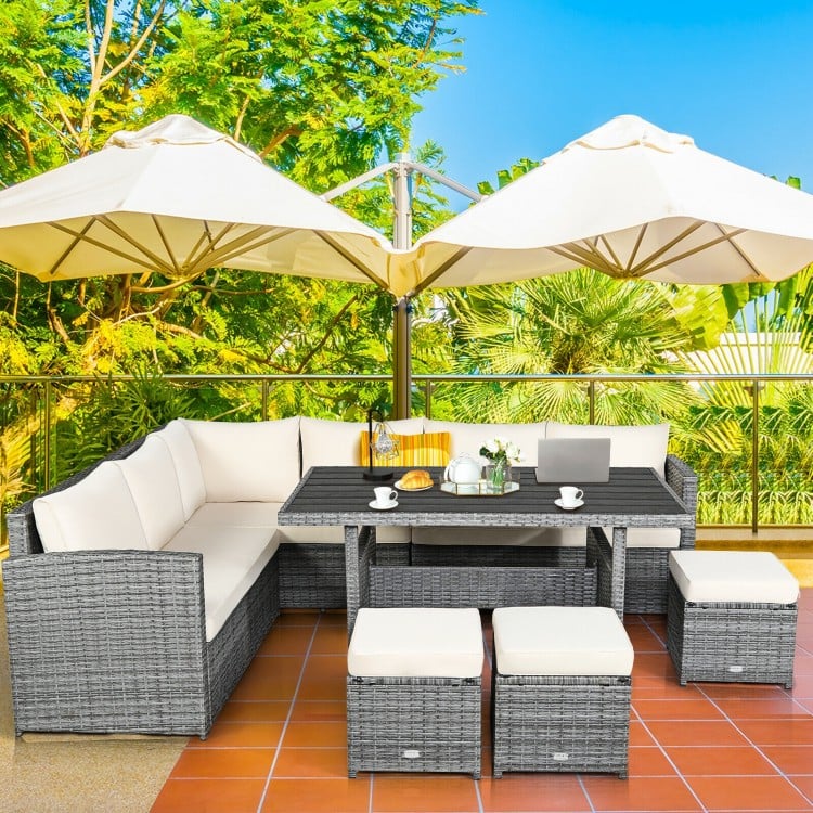 Sectional sofa set with off-white cushions, featuring rattan construction and a spacious table for outdoor dining.