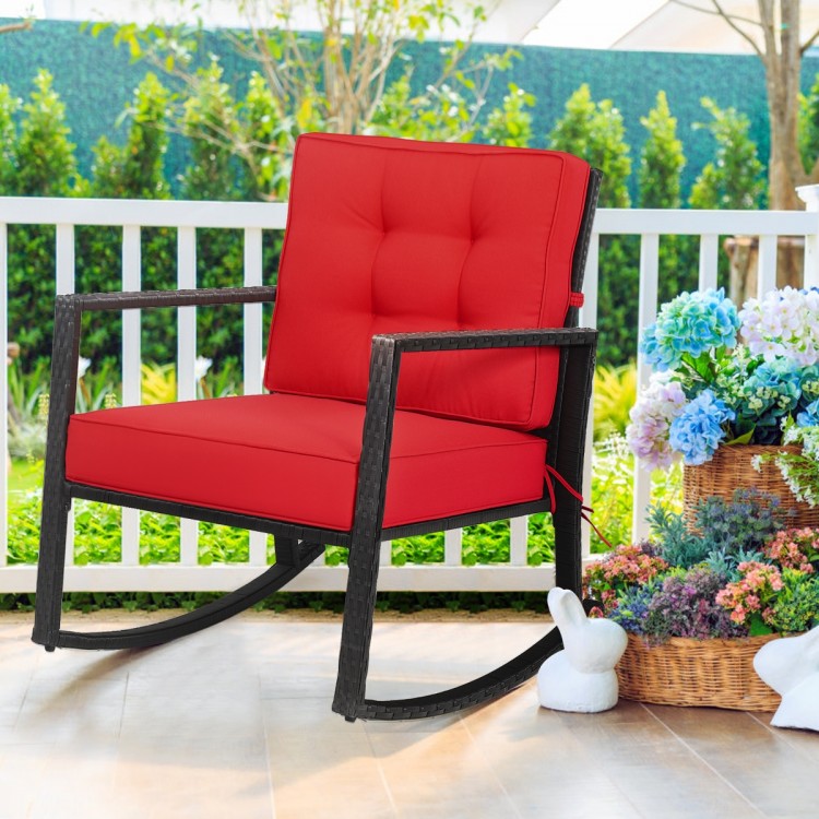 Red rocking chair with thick cushions and PE rattan, designed for comfort and style in outdoor spaces like patios or.