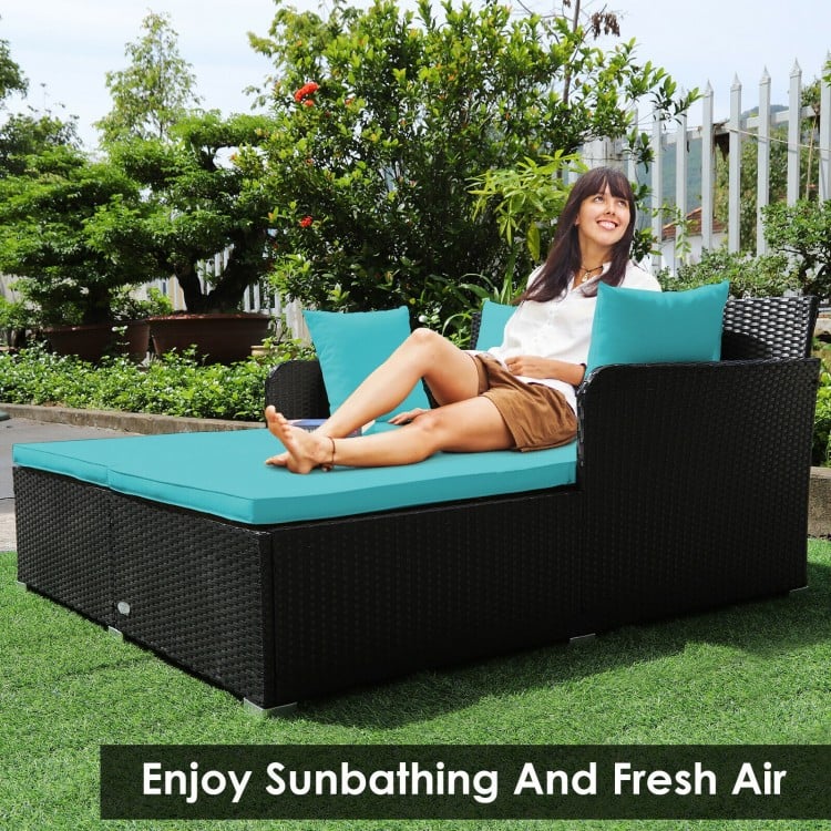 Spacious outdoor rattan daybed in turquoise with cushions and pillows, perfect for sunbathing and relaxation.