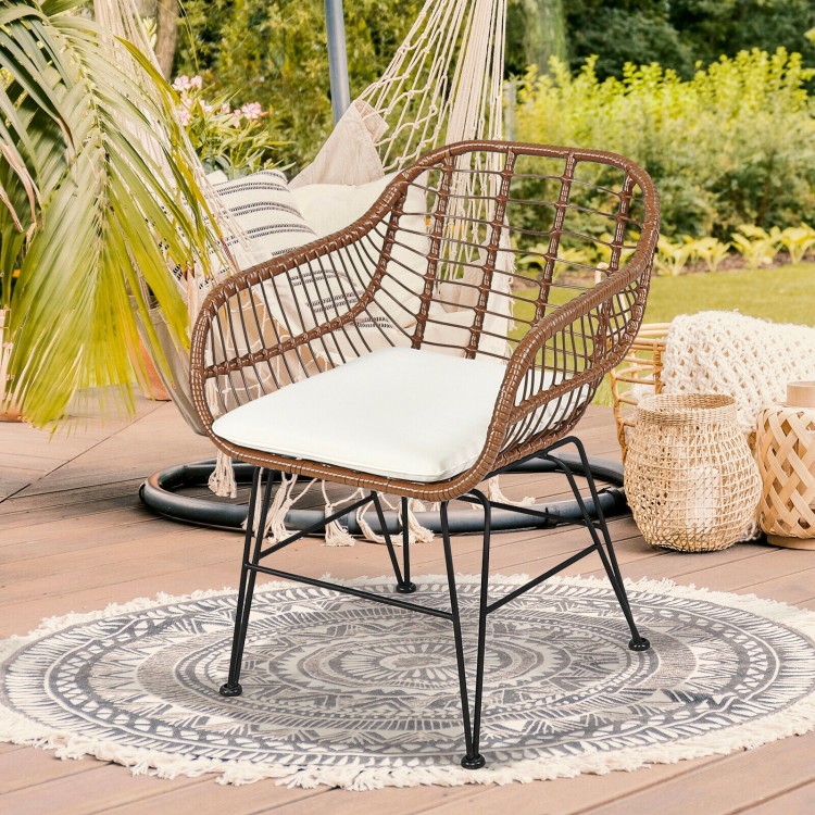 Rattan armchair with white cushion, featuring durable construction and stylish design, perfect for patio or garden use.