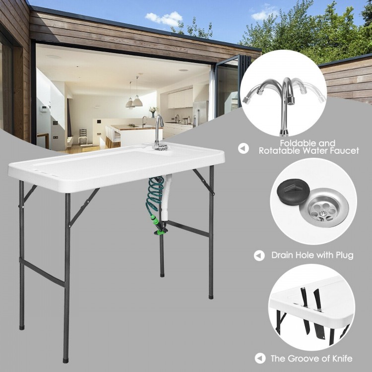 Folding cleaning sink table with sprayer, durable plastic surface, integrated drain, perfect for outdoor cleaning tasks.