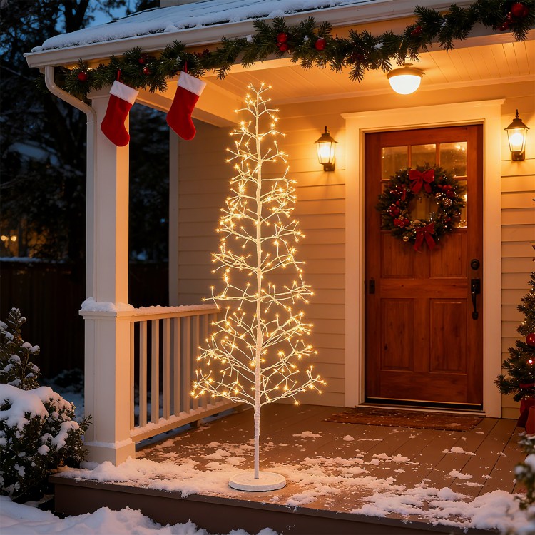 6 FT lighted birch tree with 320 warm white LED lights, elegantly placed on a snowy porch for festive ambiance.