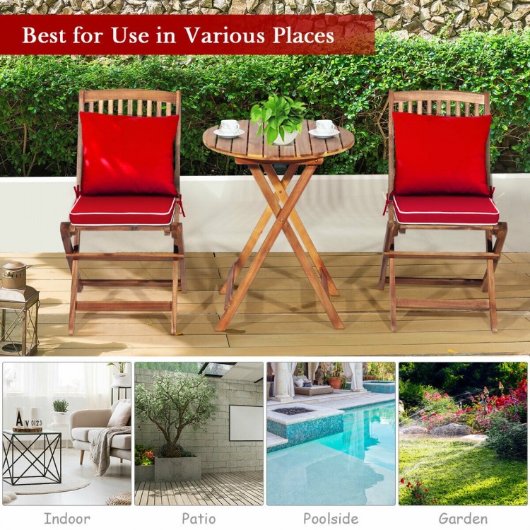 Folding wooden bistro set with red cushioned chairs and a table, perfect for outdoor patio or garden use.