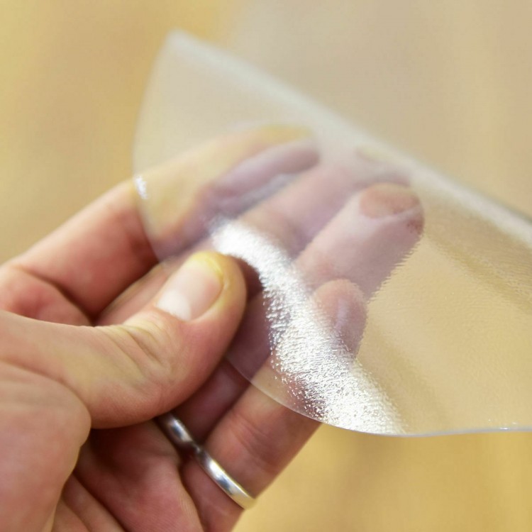 Transparent PVC chair floor mat showcasing its flexible texture, designed to protect hardwood floors from damage.