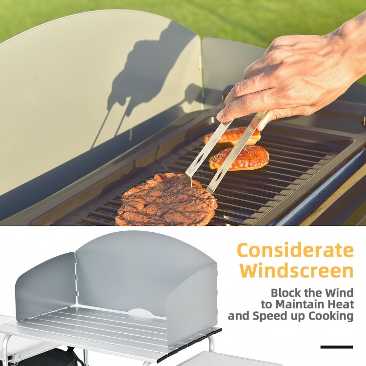 Folding camping table with gray windscreen, large heat-resistant countertop, ideal for outdoor cooking and barbecues.