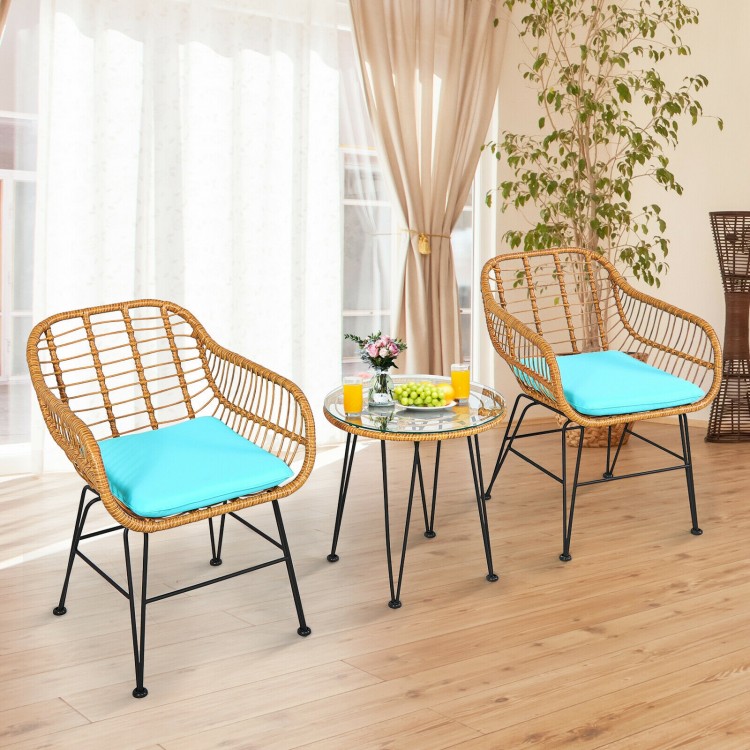 Two cushioned rattan chairs with a round glass table, perfect for outdoor patio relaxation and entertaining.