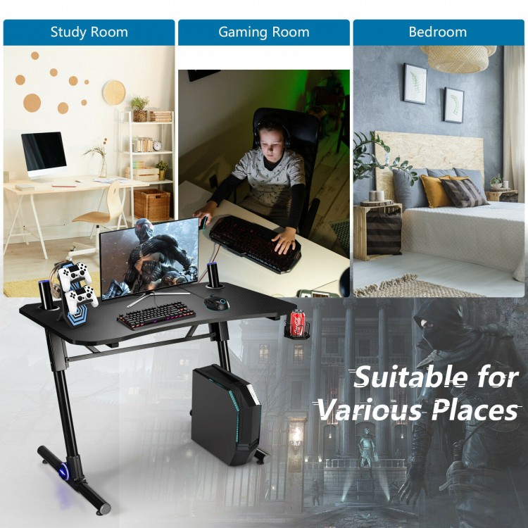 Height adjustable gaming desk with blue LED lights, carbon fiber surface, and sturdy Z-shaped legs for versatile use.