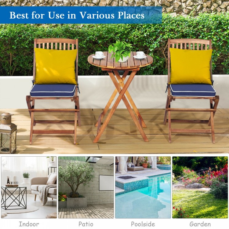 Folding wooden bistro set with cushioned navy chairs and a round table, perfect for outdoor patio or garden use.