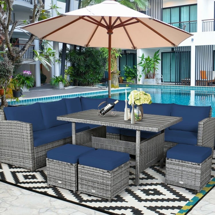 7-piece patio rattan dining set featuring navy cushions, a table, and ottomans, perfect for outdoor relaxation by the.