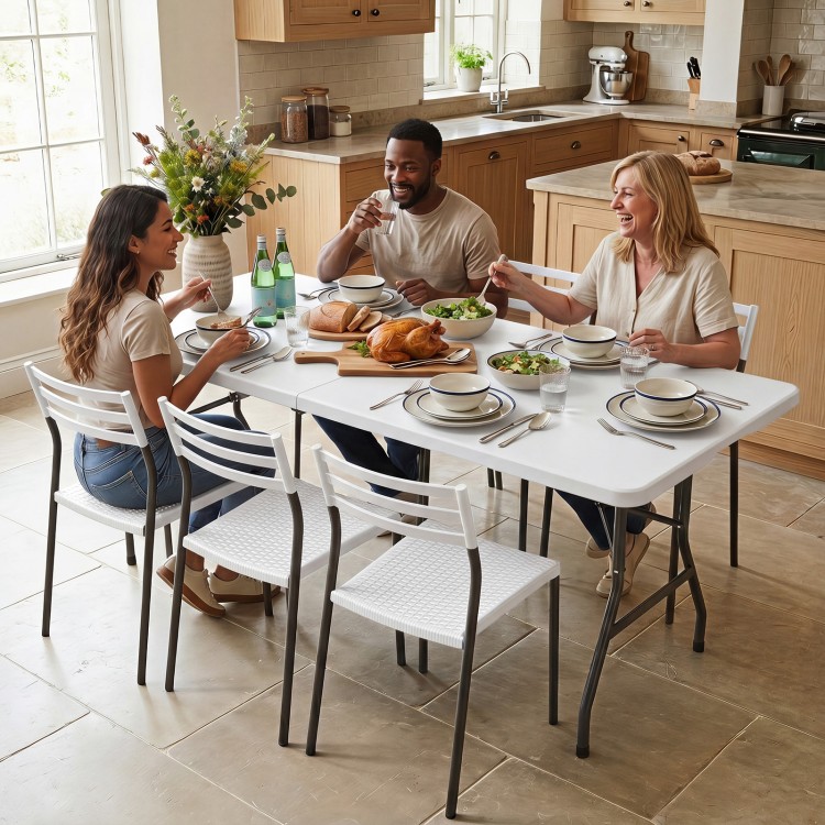 A group of three friends enjoying a meal at a 6 FT white plastic fold-in-half camping table with a rattan texture.