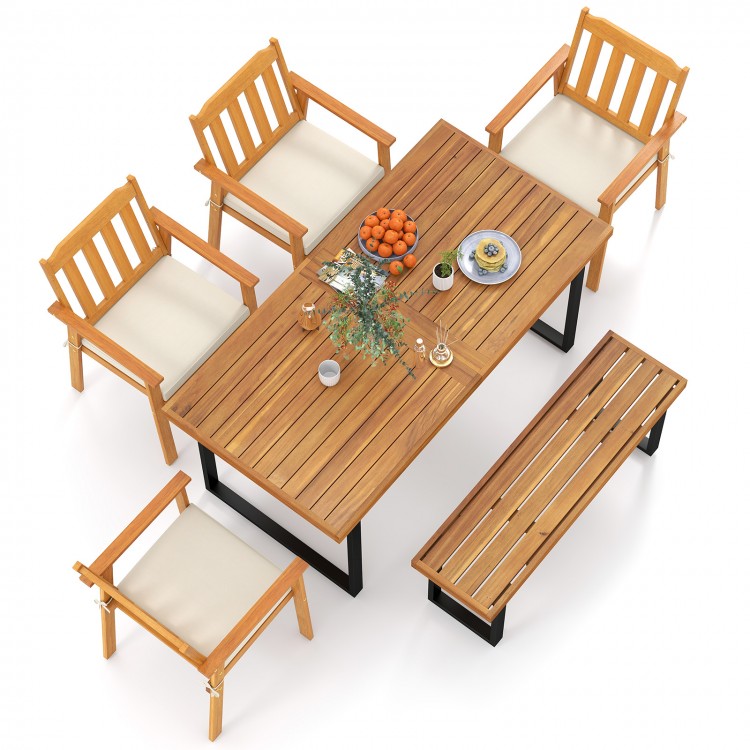 Back view of a rustic 63” acacia wood dining table surrounded by four armchairs and a backless bench, perfect for.