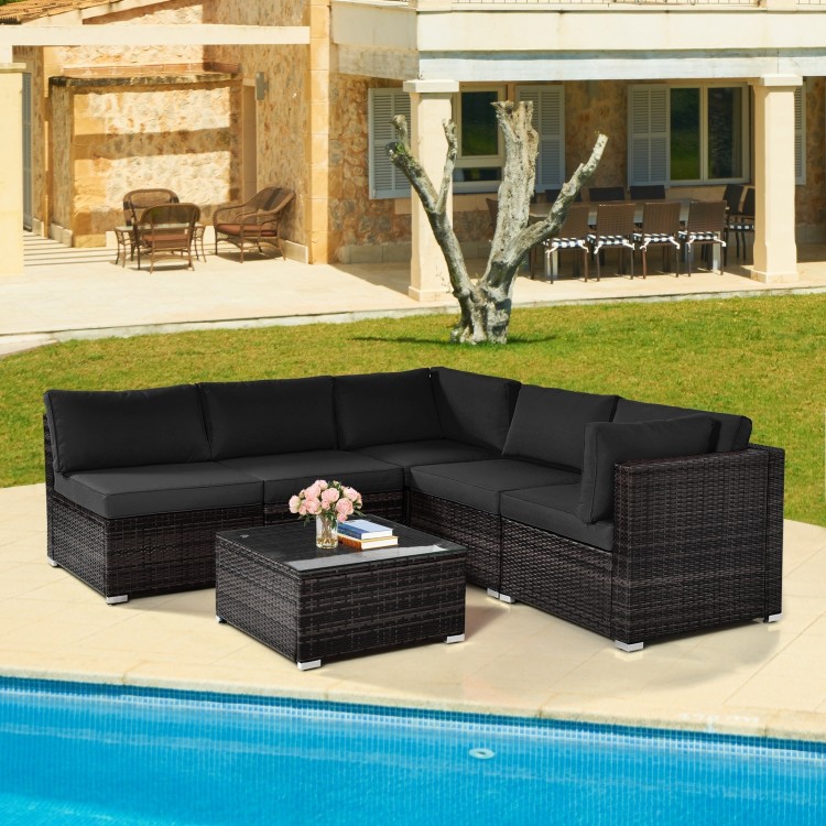 Black 6-piece patio rattan furniture set with cushions and glass coffee table, perfect for outdoor relaxation by the.