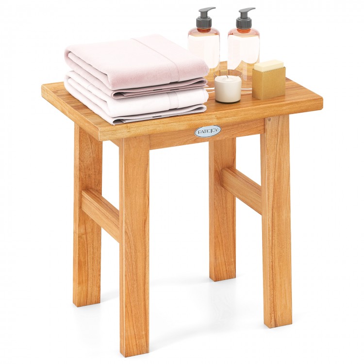 Teak shower bench with towels and toiletries, ideal for shaving legs and adding elegance to any space.