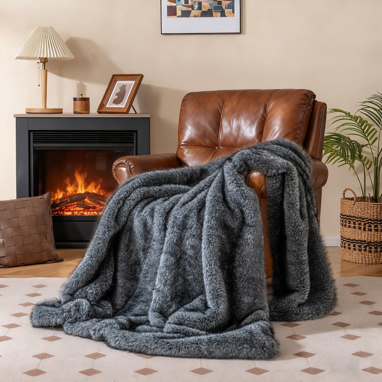 Soft plush gray faux wolf fur blanket draped over a leather armchair, ideal for cozying up on sofas or beds.