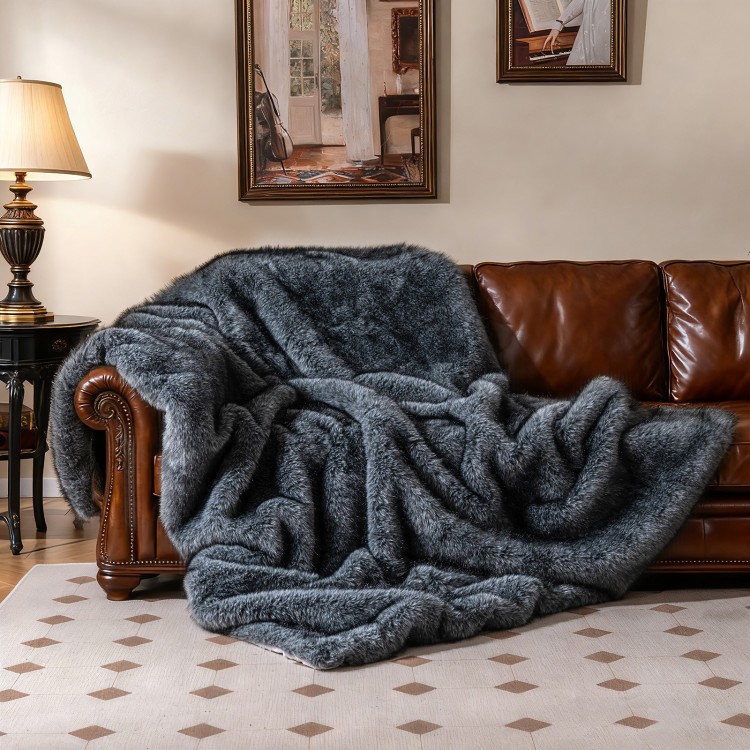 Gray plush faux wolf fur blanket draped over a leather sofa, featuring a soft texture and double-sided design for.