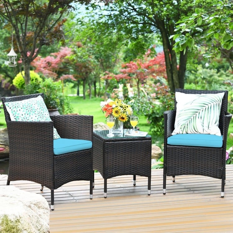 3-piece patio furniture set featuring two blue cushioned rattan chairs and a glass-top coffee table for outdoor.