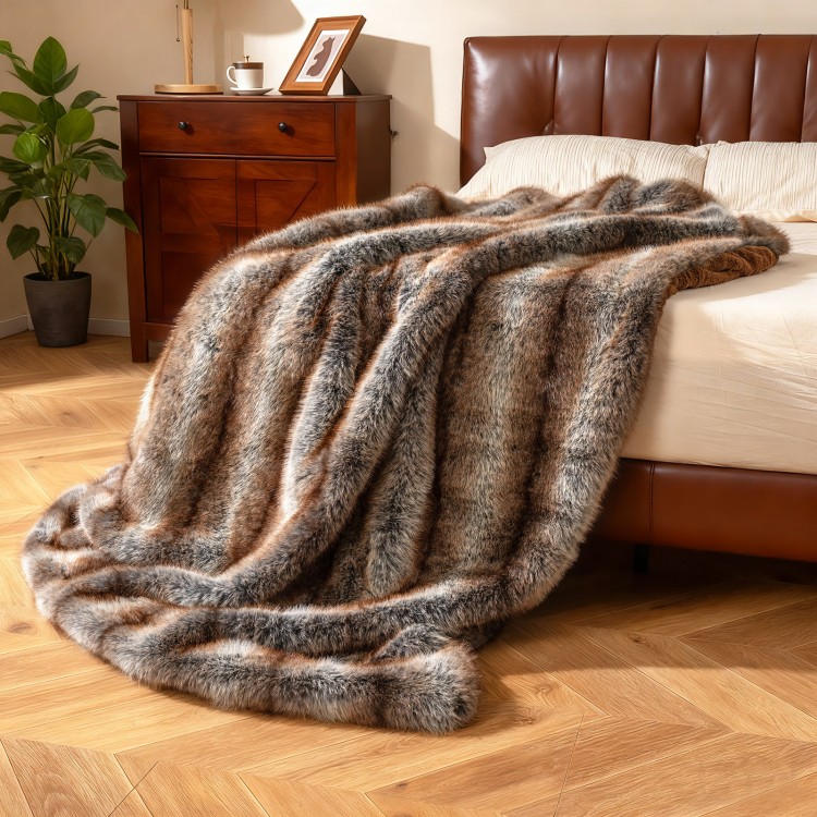 Soft plush fuzzy luxury faux fox fur blanket in brown, draped over a bed, ideal for sofas and armchairs.